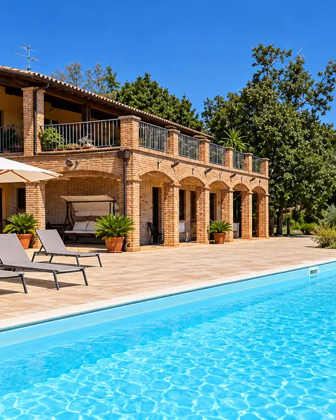 La piscina e i lettini davanti alla casa con il portico ad archi